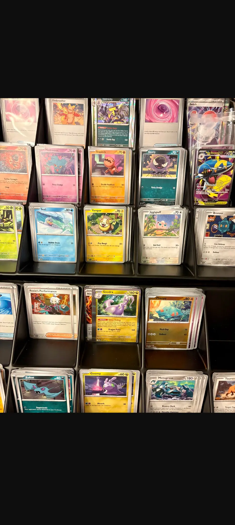 Pokémon single cards sorted into black trays